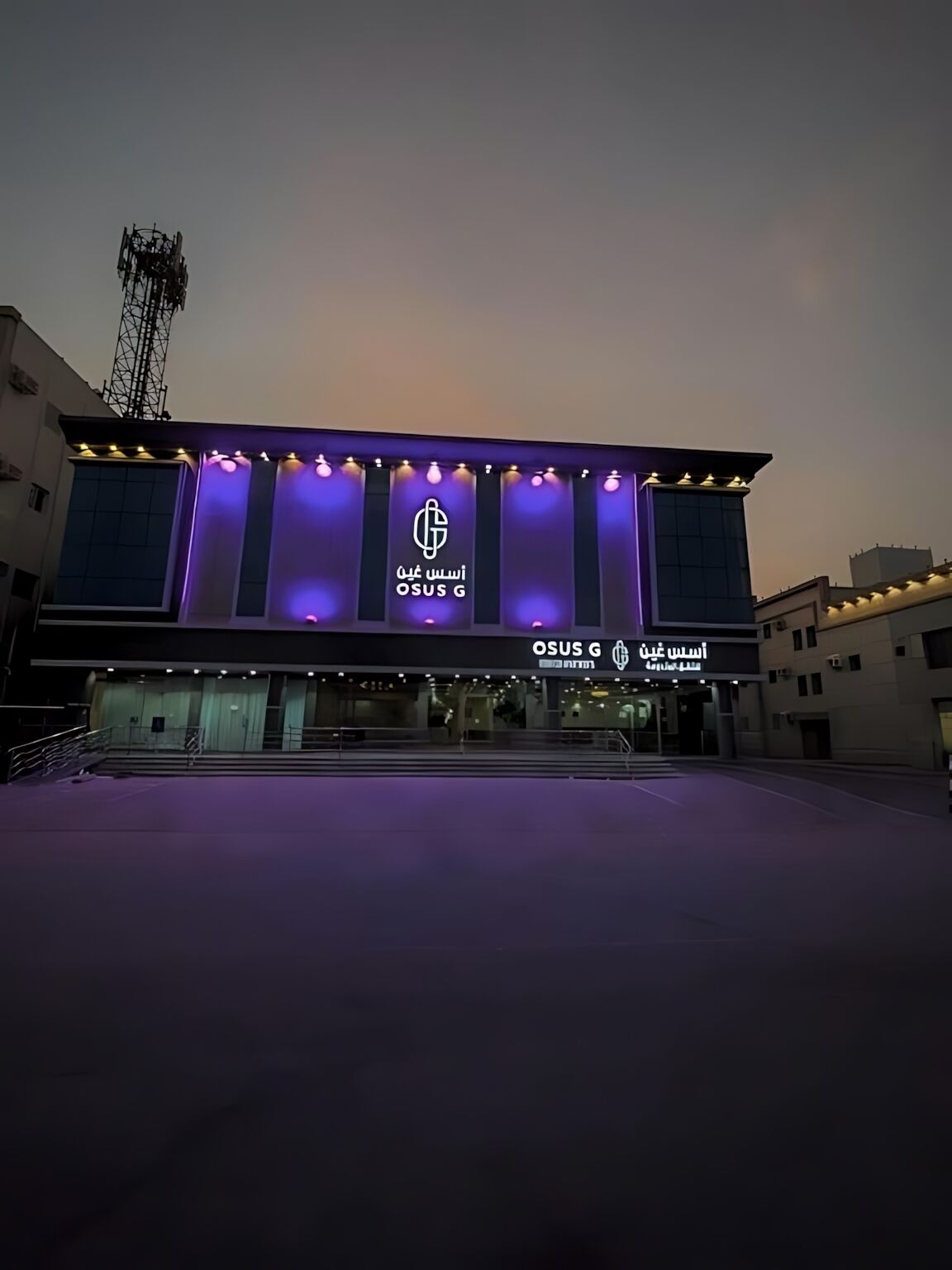 A building with a prominent OSUS G logo and signage in both English and Arabic.