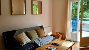 Un salon comprenant un canapé, une table basse et une porte donnant sur un espace extérieur.