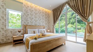 Ein Schlafzimmer mit einem großen Bett, einem Nachttisch mit einer Vase und einem Fenster mit Vorhängen.
