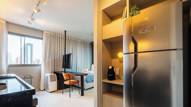 Une chambre d’hôtel moderne dotée d’un coin cuisine, d’une table à manger et d’un canapé.