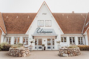 Ein traditionelles Gebäude mit einem steilen Satteldach und einer Stein-Fassade, auf der das Jahr 1984 verzeichnet ist.