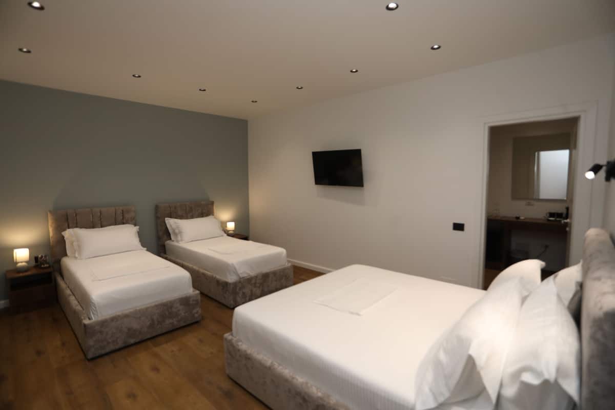 Family Quadruple Room, Patio, City View | In-room safe, desk, laptop workspace, iron/ironing board