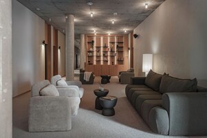 Una sala de estar moderna con un conjunto de sofá, una mesa de centro y una estantería.