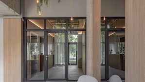 Un interior moderno con asientos, plantas colgantes y luz natural.
