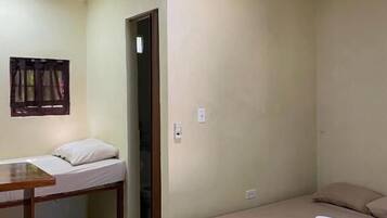 Un alojamiento pequeño y de una sola habitación, con una cama, un escritorio y una silla.