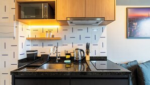 Una cocina moderna con microondas, estufa y pileta.
