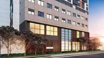 Un immeuble moderne à plusieurs étages, doté de grandes fenêtres et d’une façade plane.