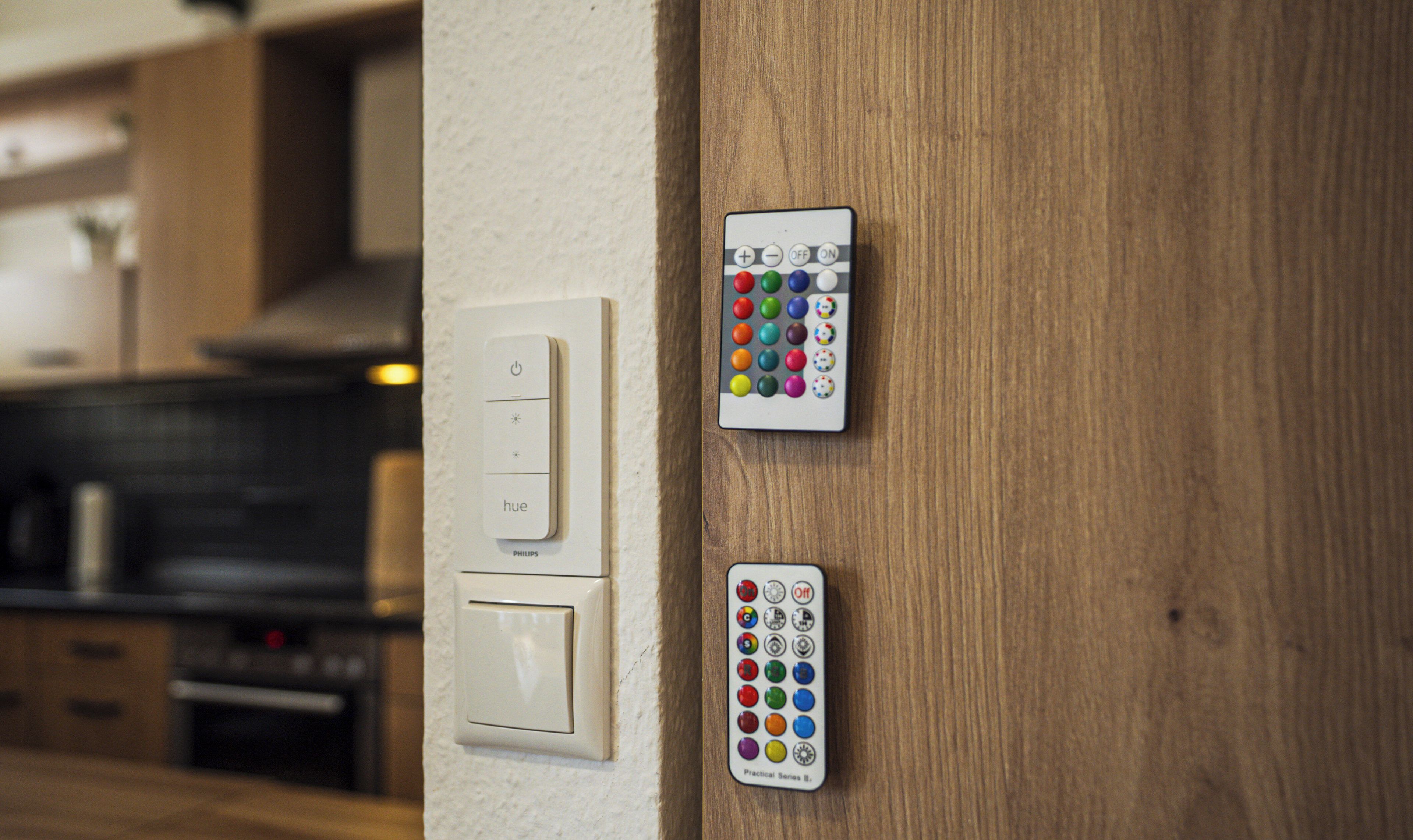 A wall-mounted control panel with multiple buttons and a remote control.