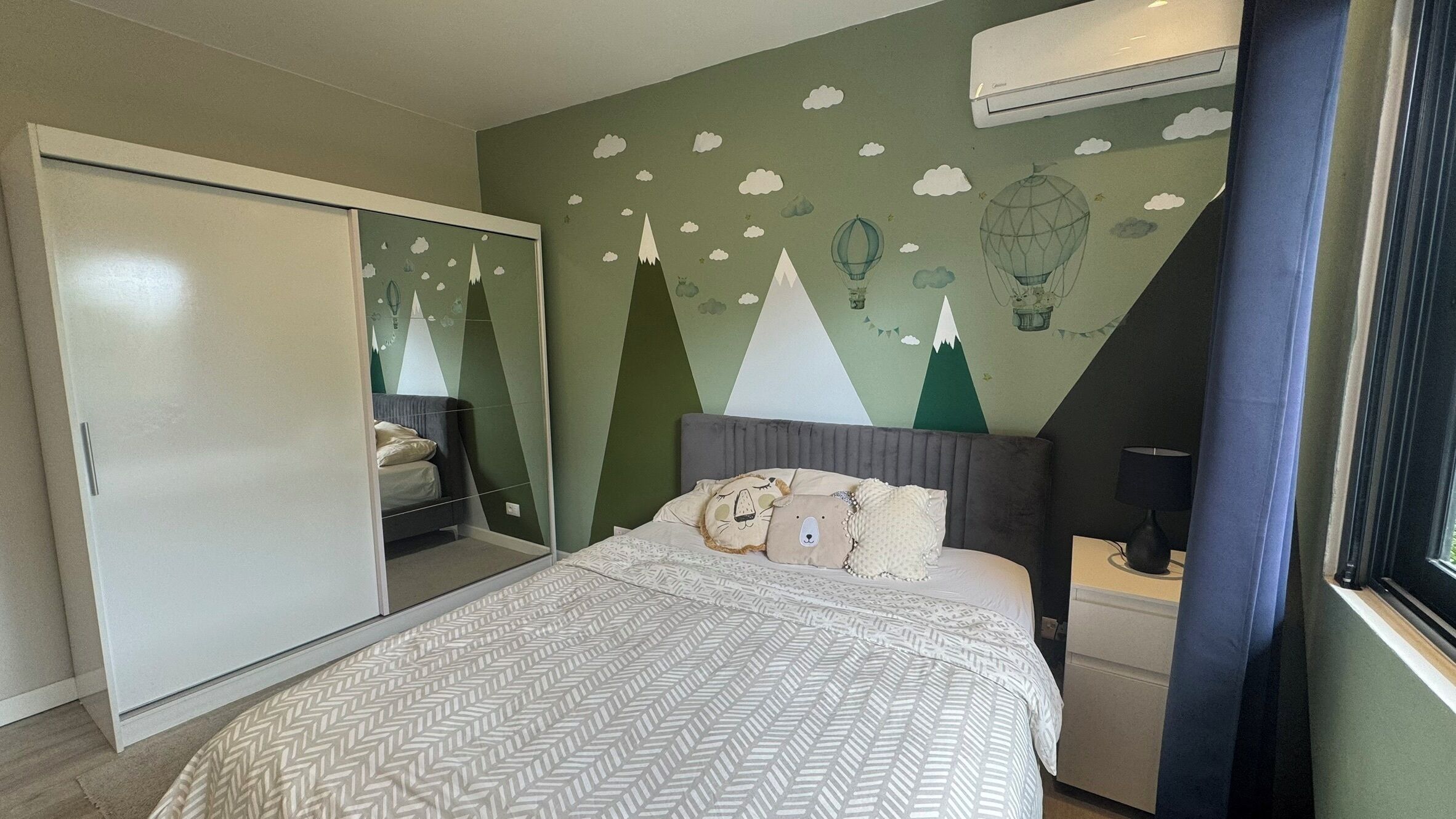 A bedroom with a bed, nightstand, and wardrobe.
