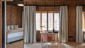 A room with a wooden ceiling, a bed, a desk, and a chair. - Hotel Krone (Oettingen in Bayern)