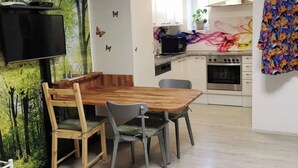 Een moderne keuken met een eethoek, met een flatscreen-televisie, een magnetron en een oven.