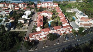 Vue aérienne d’une zone résidentielle côtière, avec des bâtiments, des routes et une plage.
