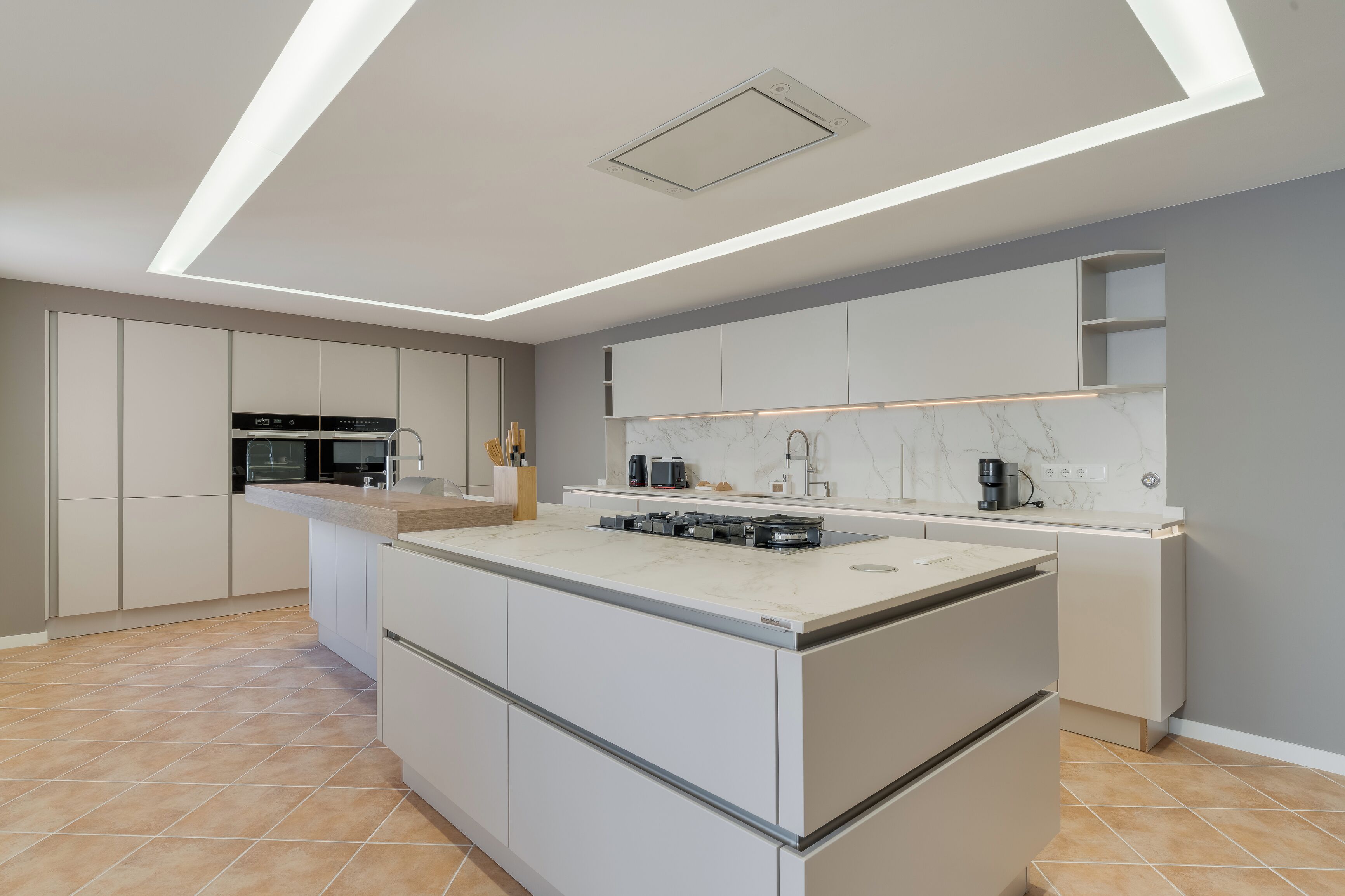 Une cuisine moderne dotée d’un îlot central, d’appareils électroménagers intégrés et d’un design épuré.