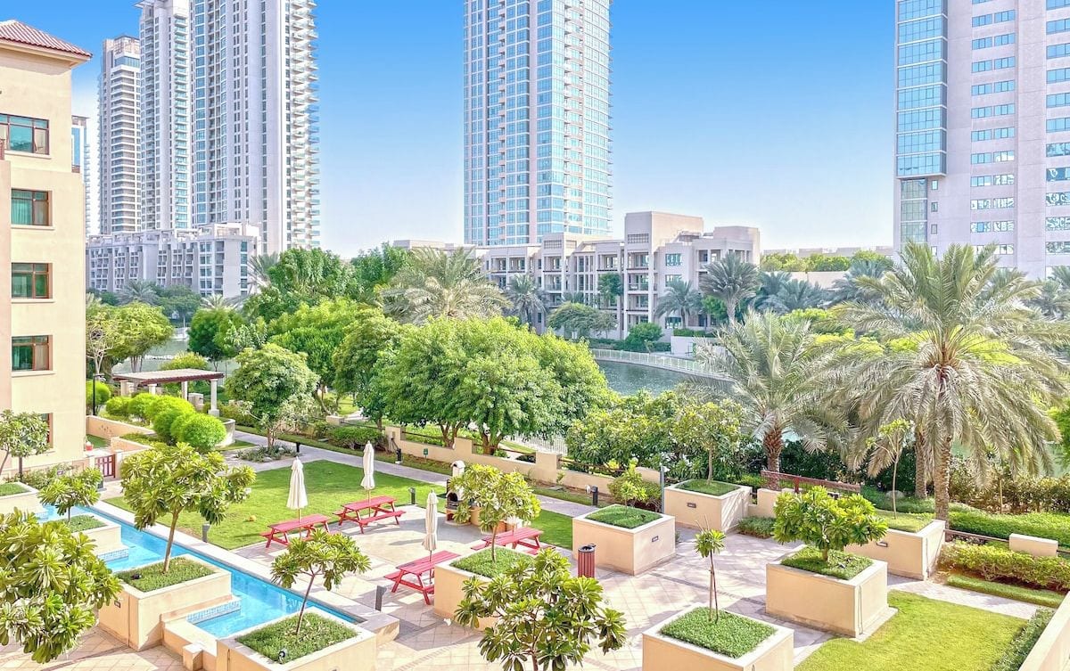 A modern residential area with high-rise buildings, a swimming pool, and well-maintained greenery.
