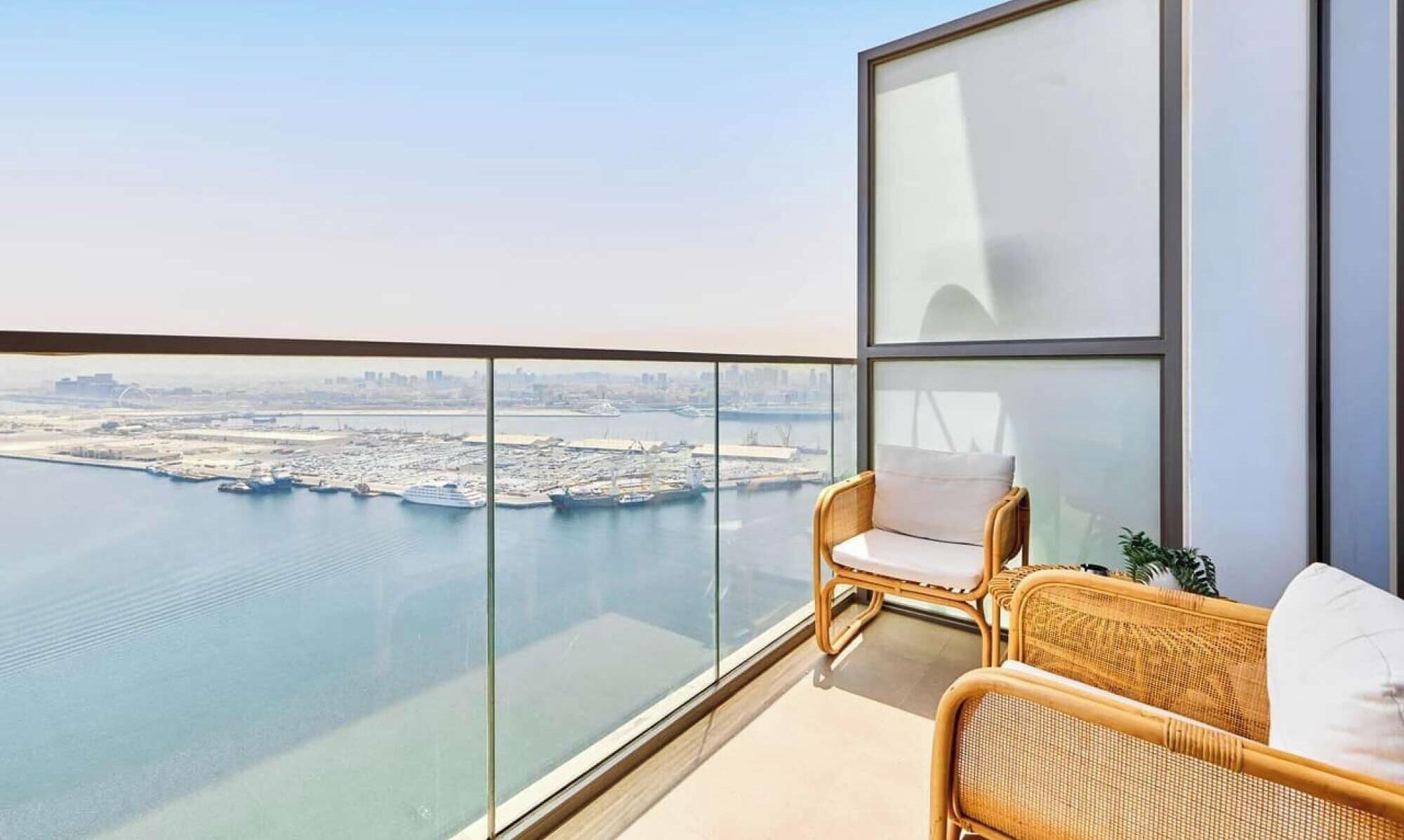 A balcony with a view of a marina and cityscape.