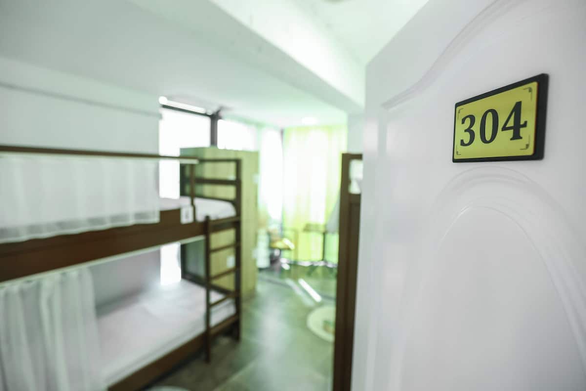 A bunk bed room with a number sign '304' on the wall, indicating room number.