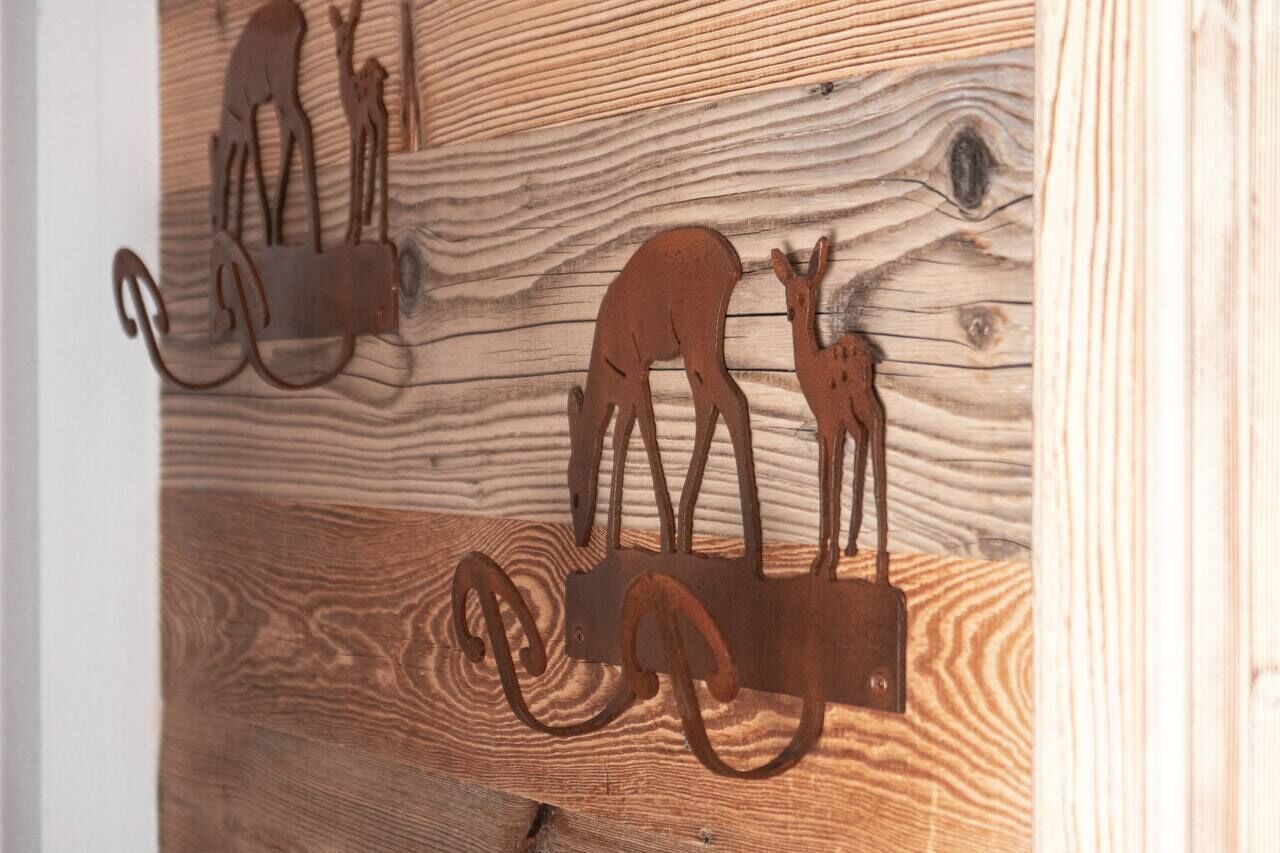Un mur en bois orné de crochets en métal en forme d’animaux.