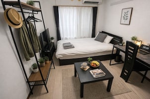 Cubrecamas, espacio para trabajar con laptop y cortinas blackout