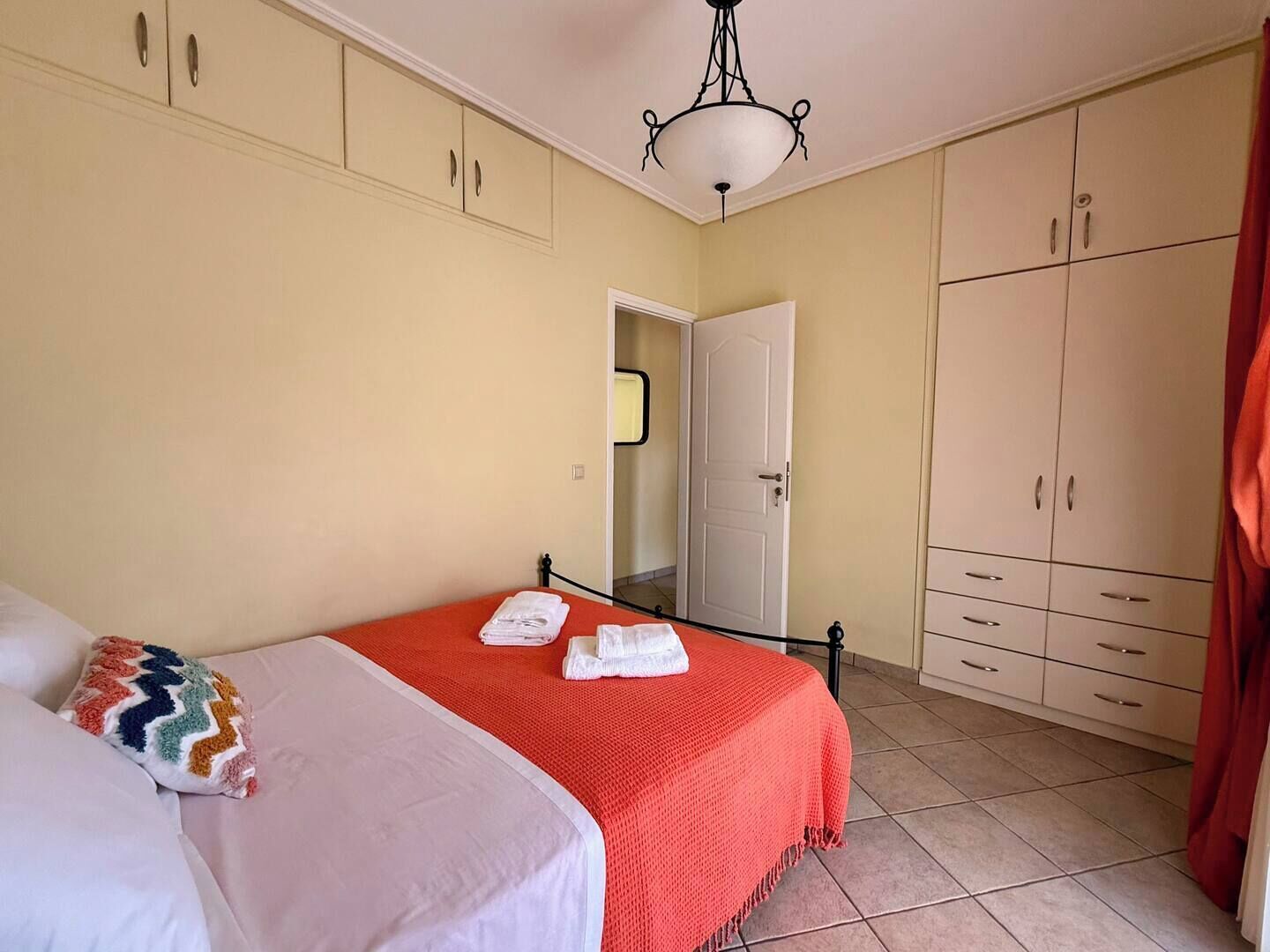Un dormitorio con una cama, un armario y una puerta que da a otra habitación.