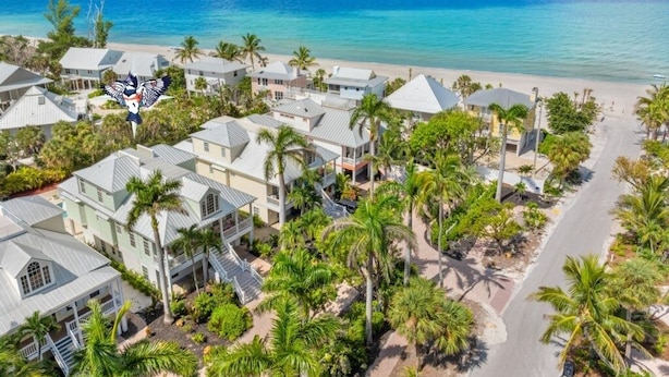A coastal residential area with houses, palm trees, and a beach. - Summer Breeze 7 Bedroom Home (Captiva)