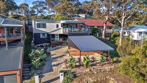 A residential area with modern houses, a driveway, and a well-maintained garden. - Modern 4BR Mirraboo Home with Panoramic Lake Views (Mirrabooka)