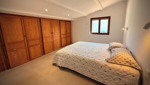 A bedroom with a large bed, wooden wardrobe, and a window. - Maison Sud: Between sea and vineyards (Martigues)