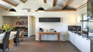 A modern kitchen with a dining area, wooden beams, and a flat-screen TV. - 3 bedroom lovely home in Beesel (Beesel)