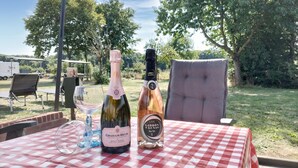 A table with a checkered tablecloth, two bottles of wine, and a glass. - 3 bedroom lovely home in Beesel (Beesel)