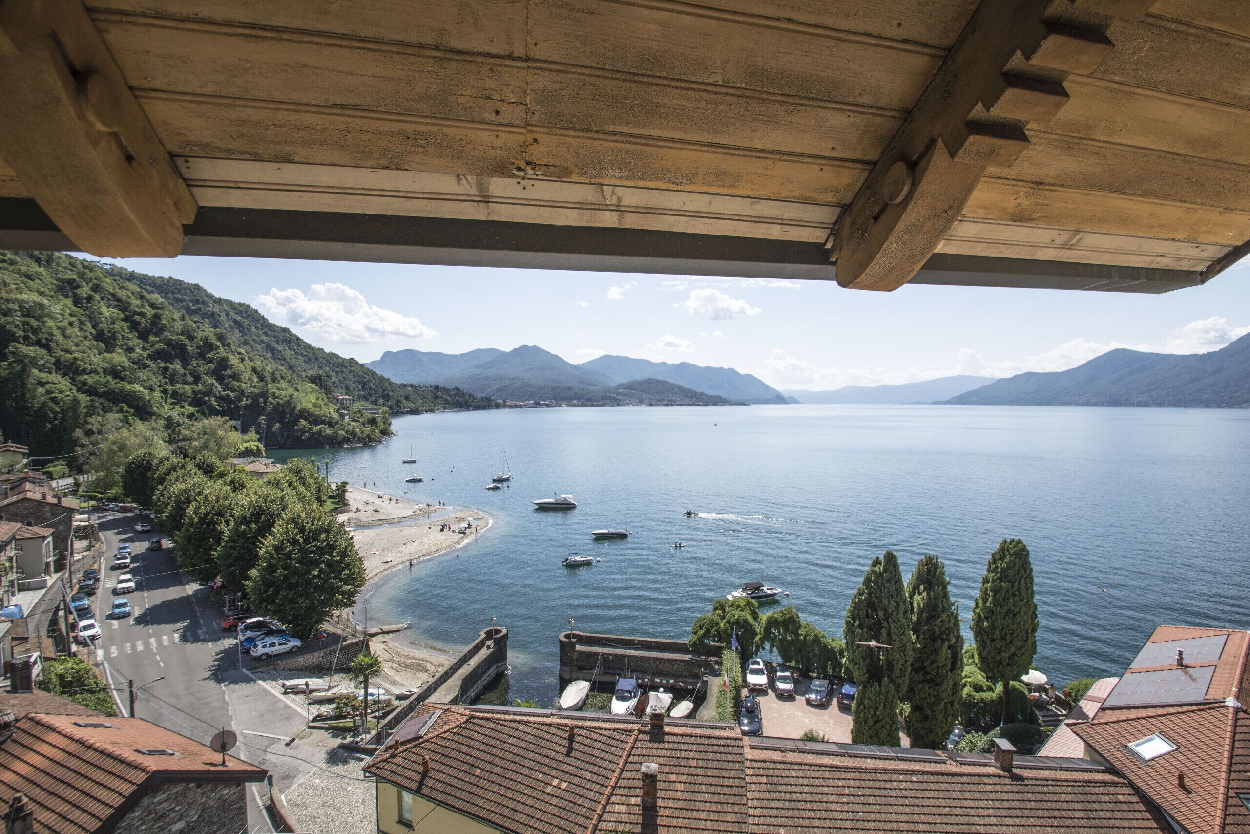 Uma cidade costeira com um porto de iates, barcos e vista para o mar e montanhas.