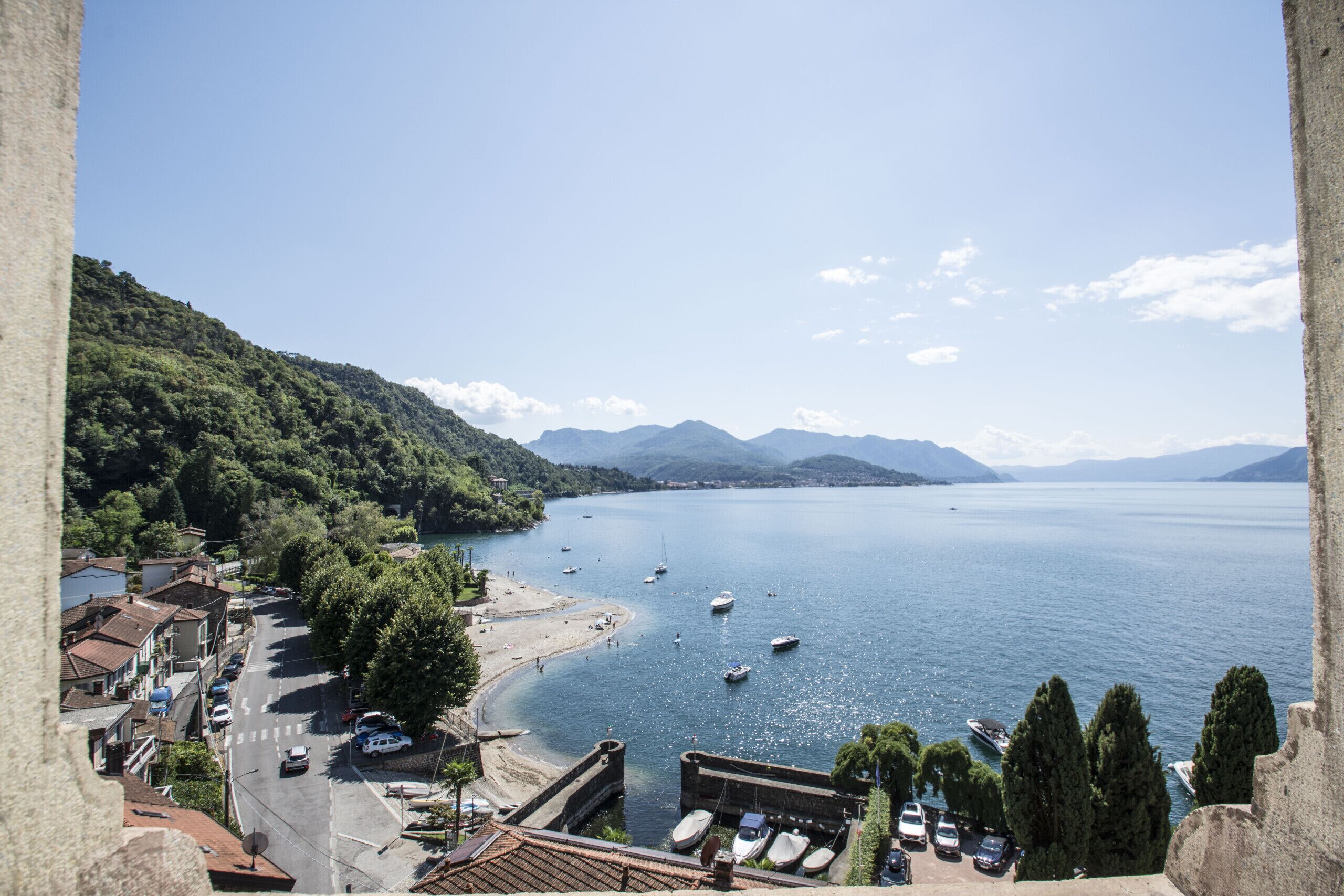 A coastal town with a marina, boats, and a mountainous backdrop.
