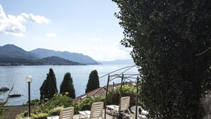 A terrace with outdoor seating, overlooking a lake and mountains. - Casa Jolanda (Luino)