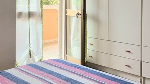 A bedroom with a bed, a wardrobe, and a sliding glass door leading to a balcony. - Apartment in La Caletta 5 minutes from the beach (La Caletta)