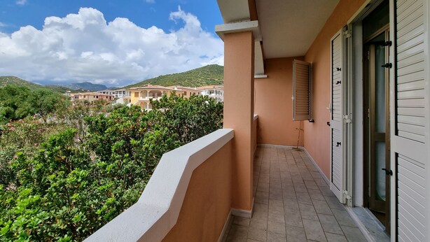 A balcony with a view of a hillside and buildings in the background. - Apartment in La Caletta 5 minutes from the beach (La Caletta)