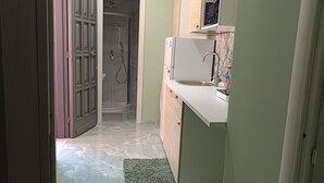 Un pasillo estrecho que conduce a un baño con ducha e inodoro.