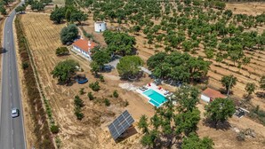 An aerial view of a property with a swimming pool, solar panels, and a road nearby. - Alma Alentejo Villa (Odemira)