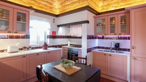 A kitchen with pink cabinets, a wooden ceiling, and a window. - Aposento Real Villas (Montemor-o-Novo)