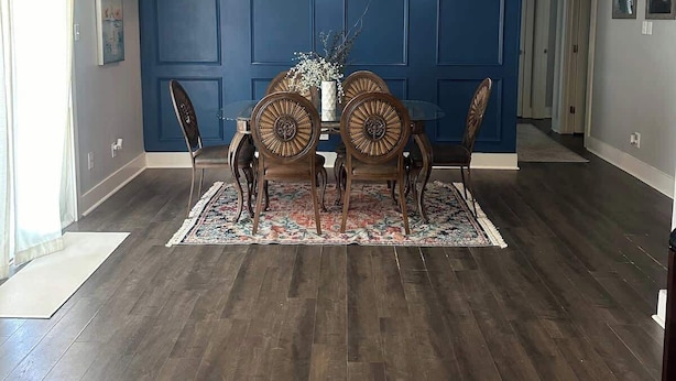 A dining area with a dark wood floor, a blue wall, and a dining table with four chairs. - 3 bedroom walk to the beach! (Galveston)