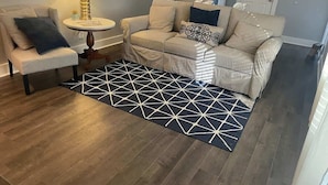 A living room with a sofa, armchairs, a coffee table, and a patterned rug. - 3 bedroom walk to the beach! (Galveston)