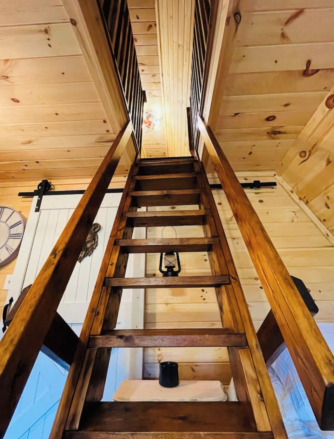 A wooden staircase with a clock on the wall.