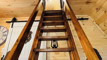 A wooden staircase with a clock on the wall.