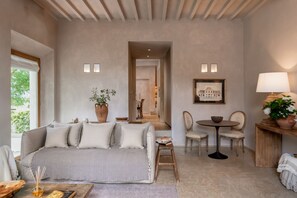 A cozy room with a bed, a small table, chairs, a potted plant, and a framed picture on the wall. - The Romantic Olive Reatreat with pool and garden near Florence (Lastra a Signa)