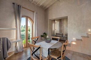 Un comedor con una mesa redonda, sillas de madera y vistas al exterior.