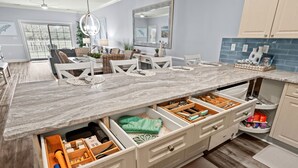 Una cocina moderna con encimera de mármol, cajones integrados y vistas al comedor.