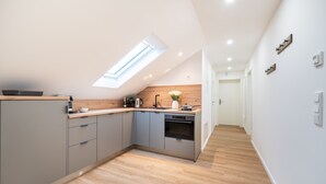 A modern kitchen with a skylight, grey cabinets, and a wooden countertop. - RAW-Flats Milse - Modern. Stylish (Bielefeld)