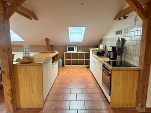 Cozinha com armários de madeira, micro-ondas e painel de azulejos.