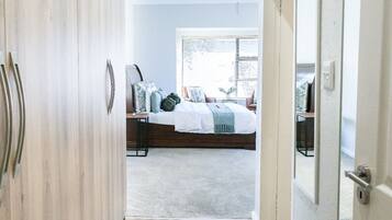A bedroom with a bed, bedside tables, and a window with blinds.