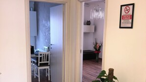 A hallway with wooden flooring, white walls, and a potted plant. - Stella apartment 10 min. from Venice (Venezia)