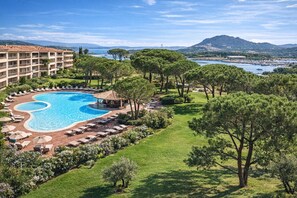 A resort with a large swimming pool, lounge chairs, and a view of the sea and mountains. - Coup de coeur - Exceptional apartment 85 m², sea view and pool Porto-Vecchio (Porto-Vecchio)