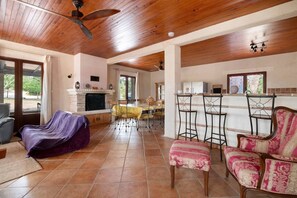 A spacious living area with a fireplace, a dining table, and a bar area with stools.