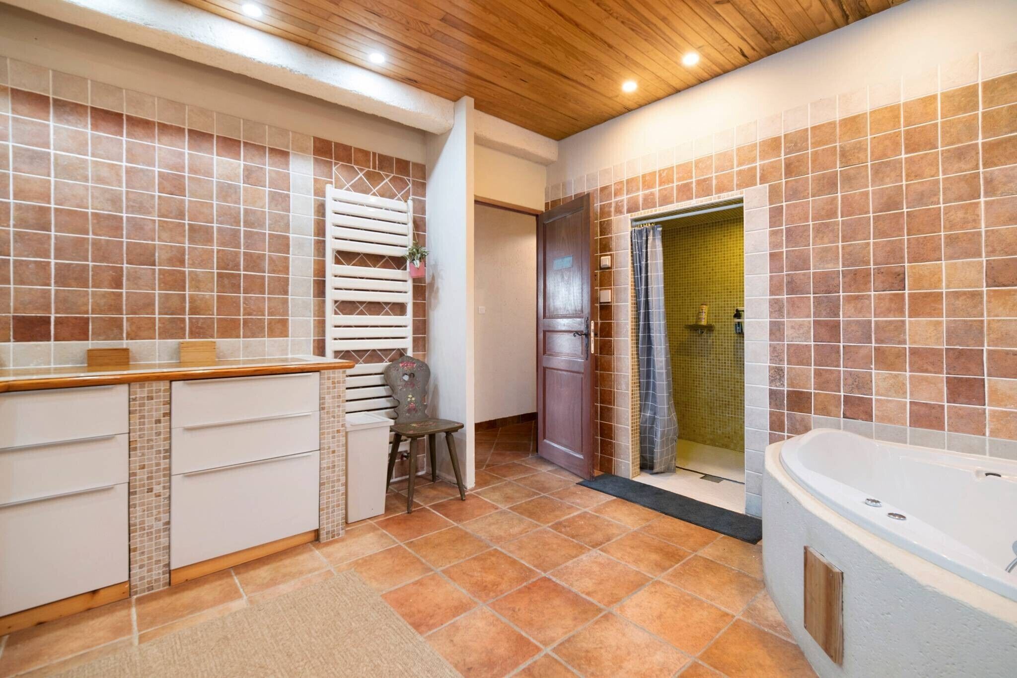 Une salle de bain avec une baignoire, un espace douche et un meuble-lavabo avec des tiroirs.